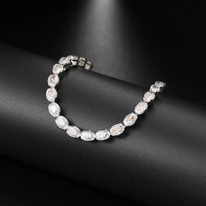 Detailed macro view of silver oval-cut cubic zirconia tennis bracelet on a black stand