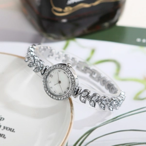 Detailed view of silver mermaid watch with leaf-shaped rhinestone strap and pearl dial