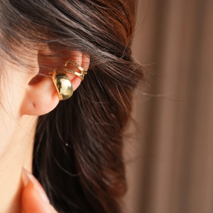 Close-up of 18k gold-plated ear cuff set with zircons shown on model's ear