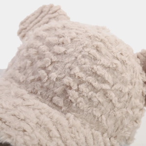 Close-up of soft beige faux shearling texture and cute 3D ears on the plush baseball cap