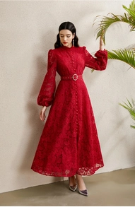 Détail d'une robe en dentelle rouge avec col montant, boutons et ceinture à boucle en cristal