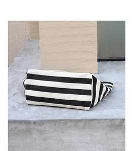 Close-up of the textured black and white striped canvas fabric on a casual handbag