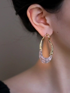 Gros plan détaillé de boucles d'oreilles en résine plaquée or 18k portées par un mannequin