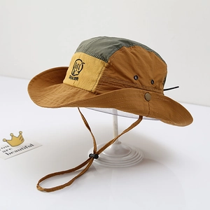 Detail of color-block sun hat with metal eyelets, snap buttons and adjustable wind cord