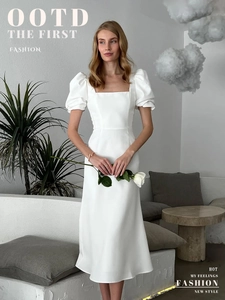 Detail of square neckline and puff sleeves on white slim-fit mid-length dress