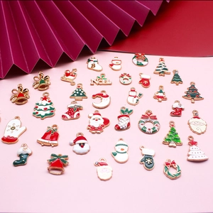 Detailed view of colorful Christmas charms including Santa, trees and wreaths on pink background