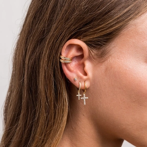 Close-up of gold-plated silver needle cross earrings set with sparkling cubic zirconia gems