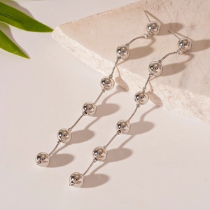 Detailed macro view of silver snake chain earrings with multi-bead long fringe drop