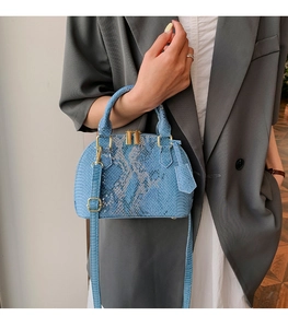 Vue détaillée du sac bleu à motif serpent avec finitions dorées et poignée supérieure