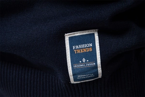 Gros plan d'un pull en maille marine avec ourlet côtelé et étiquette tissée Fashion Trends