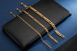 Three gold Figaro chains in different widths shown on black leather background