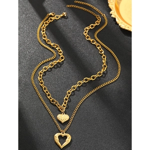 Detail of double-layer gold necklace featuring textured solid heart and hollow heart pendants