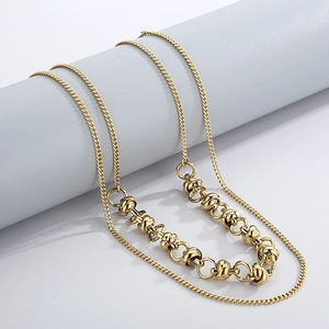 Detail of gold double-layered butterfly chain necklace with vintage knot texture