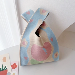 Detailed knit tote bag texture showing heart pattern and colorful patchwork fabric
