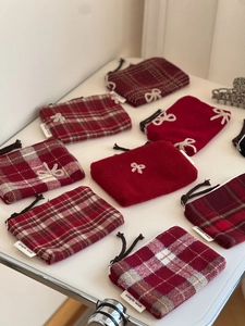 Detail of red wool plaid coin purses with bow embroidery and simple wish label tags