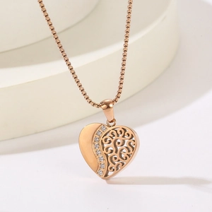 Détail du collier cœur doré avec motif filigrane ajouré et incrustation de cristaux