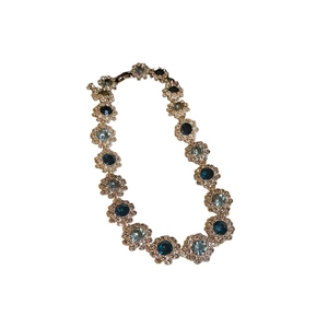 Vintage flower necklace with blue and clear crystals on a silver base, top view