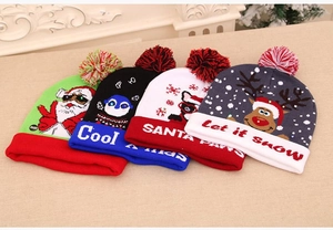 Detail of four colorful knitted Christmas hats with LED switches and festive patterns