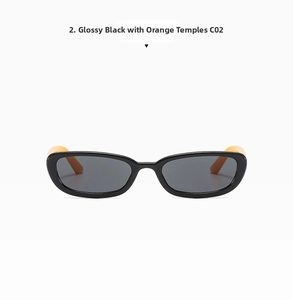 Detail view of oval cat eye sunglasses with glossy black frame and orange temples