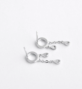 Detailed view of silver hoop earrings with delicate chain tassels and zircon teardrop charms