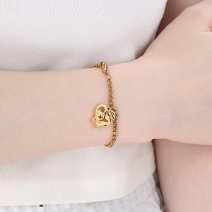 Vue détaillée du bracelet cœur doré avec silhouette mère-enfant porté au poignet