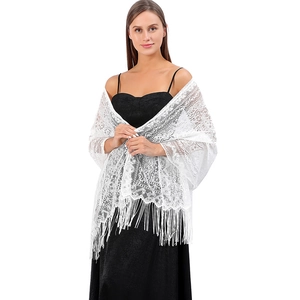 Detailed close-up of white floral lace shawl with elegant long fringe and crochet pattern