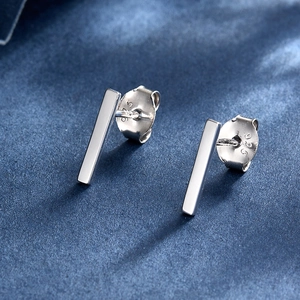 Macro view of minimalist S925 sterling silver bar stud earrings showing the 925 hallmark