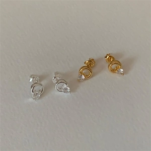 Detailed view of gold and silver sterling silver hoop earrings with clear cubic zirconia