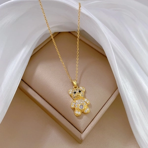 Luxurious gold bear necklace with sparkling crystals on elegant white silk background