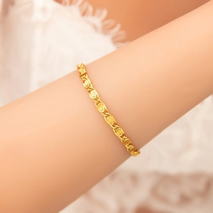 Macro detail of 18K gold plated stainless steel bracelet on wrist with elegant link design