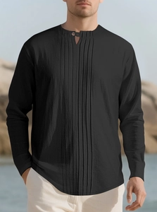 Detail of black pleated cotton linen shirt showing vertical ruffles and single button collar