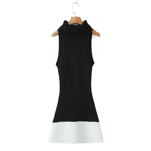 Close-up of sleeveless high neck knit dress showing the black and white contrast stitching