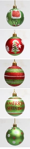 Detailed view of green and red glitter Christmas balls with festive patterns and text