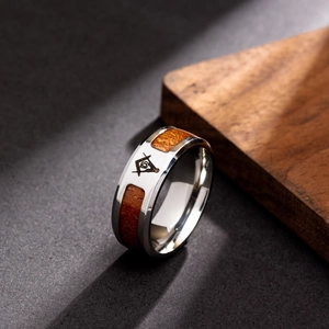 Macro-opname van titanium ring met houtinleg en gegraveerd vrijmetselaarssymbool