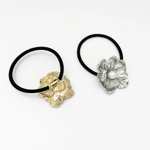 Detailed view of silver and gold floral hair ties with faux pearls and elastic bands
