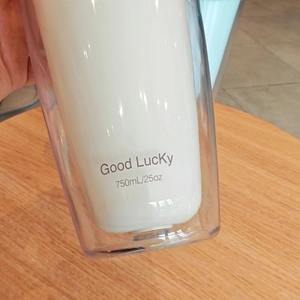 Macro shot of a hand holding a 750ml double-layer water bottle with Good Lucky print
