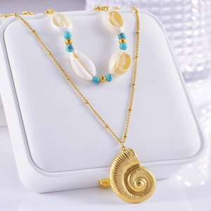 Detail of gold layered necklace featuring natural shell beads and a nautilus pendant