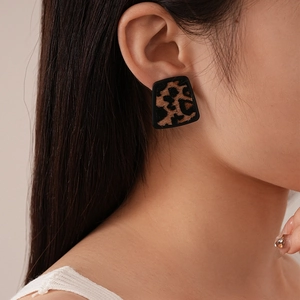 Close-up of leopard print trapezoid earring worn on model for a vintage fashion look
