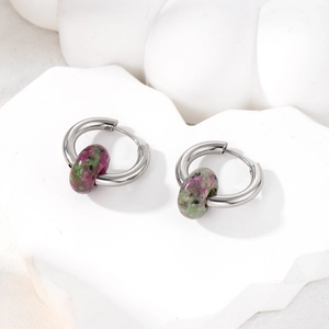 Detail of vintage stainless steel hoop earrings with natural ruby in zoisite stones
