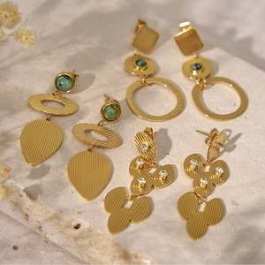 Vue détaillée de boucles d'oreilles vintage avec pierres turquoise sur fond de pierre beige