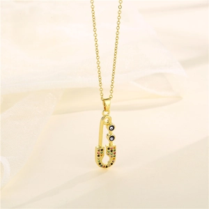 Golden safety pin necklace featuring evil eye charms and colorful zircon crystals