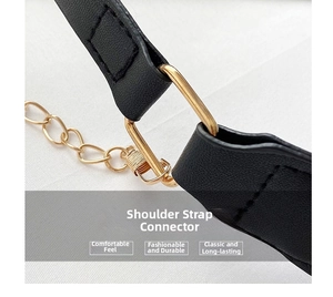 Close-up of black leather shoulder strap with golden metal rings and fine stitching detail