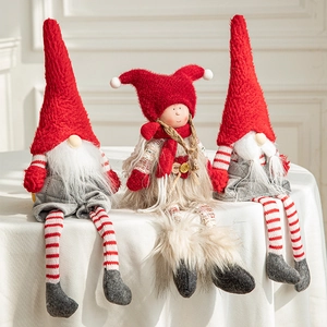 Three long-legged Christmas gnomes and doll figurines with red hats and striped socks