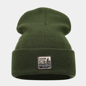 Detailed close-up of dark green ribbed knit beanie showing high-quality woven texture