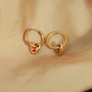 Luxurious gold-plated titanium earrings with red enamel hearts on champagne satin background