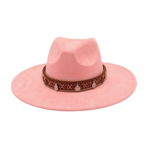 Détail d'un fedora rose avec ruban ethnique et breloques en métal vintage sur fond blanc