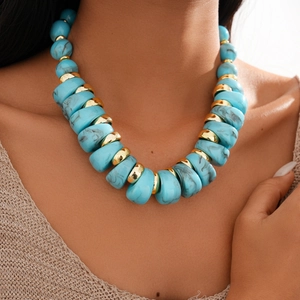 Detail of blue marble resin beads and gold metal rings on a chunky vintage necklace