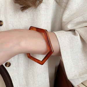 Nahaufnahme eines geometrischen Bernstein-Resin-Armbands in Sechseckform am Handgelenk