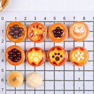 Vue détaillée de 10 miniatures de pâtisseries en résine pour maison de poupée sur règle