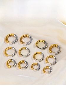 Detail of two-tone gold and silver steel hoop earrings in various sizes on silk fabric